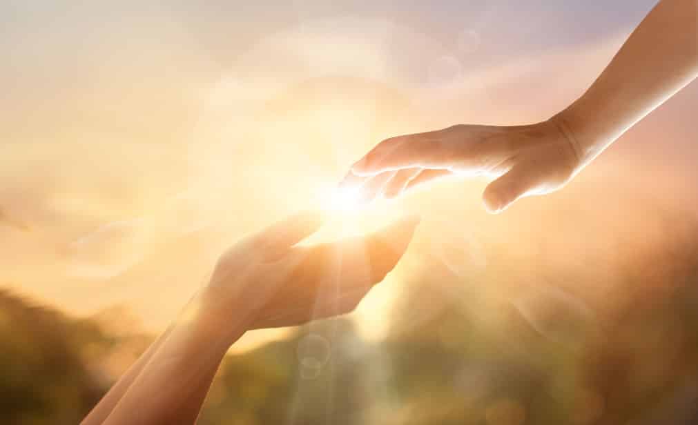 dos manos que se juntan bajo la luz del sol - La meditación de la gratitud