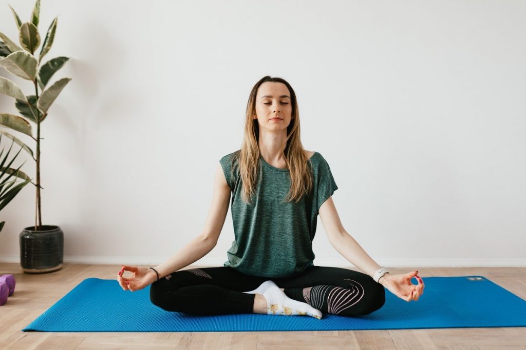 mujer meditando mientras hace yoga y desarrolla la autoconciencia